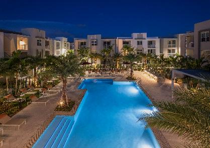 Night view of illuminated hotel swimming pool.