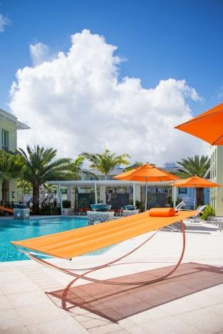 Orange hammock by a sunny poolside.