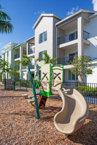 Playground slide in front of apartment building.