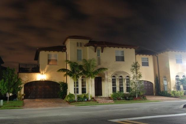 Large house with palm trees at night.