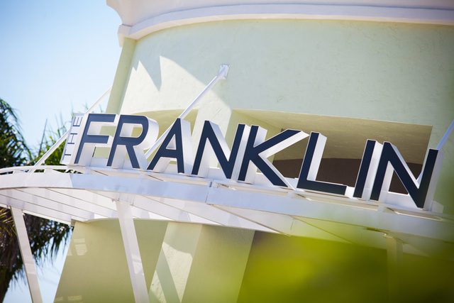 Close-up of a sign spelling 'FRANKLIN' on a light-colored wall.