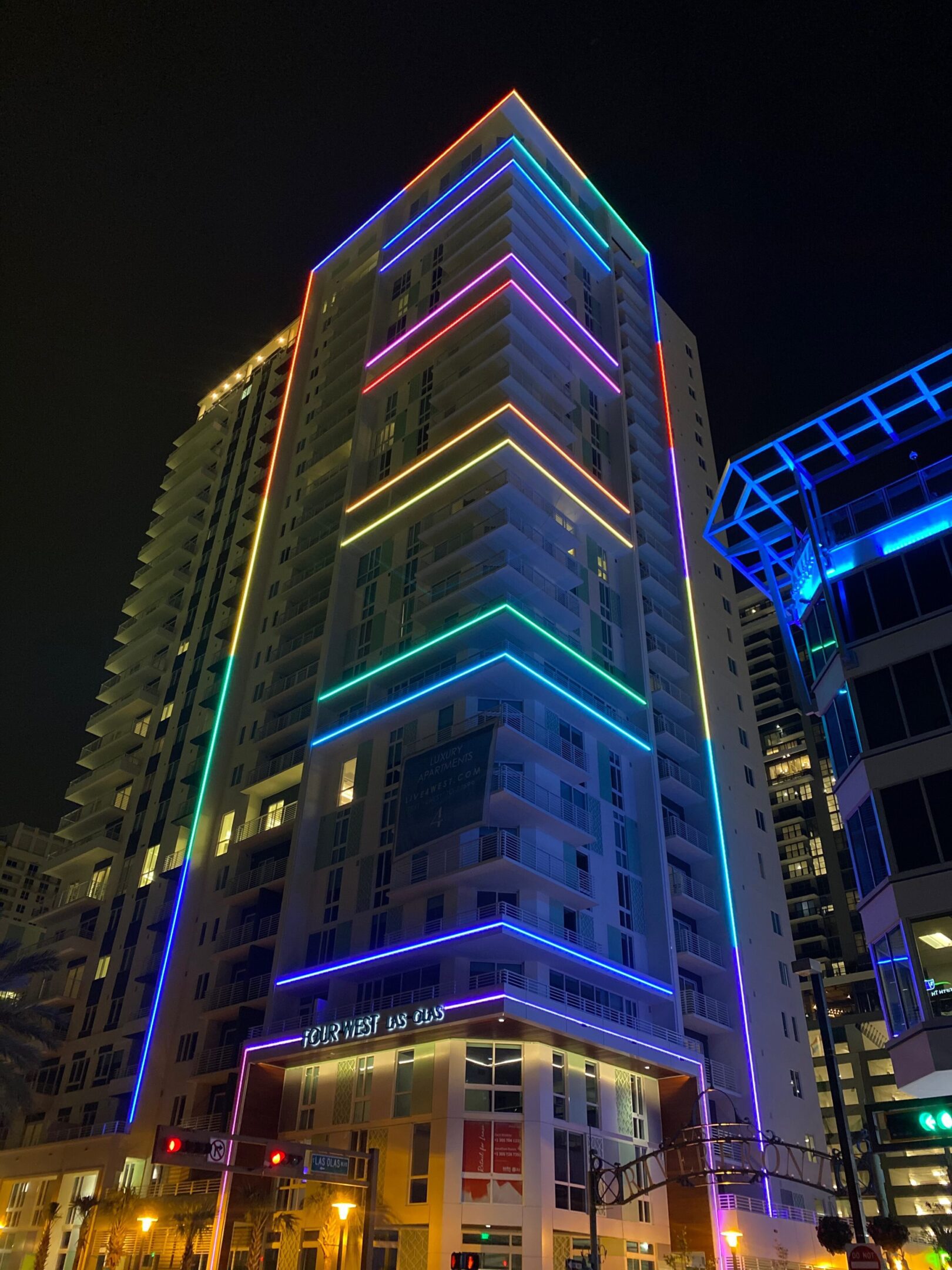 A tall building illuminated with colorful neon lights at night.