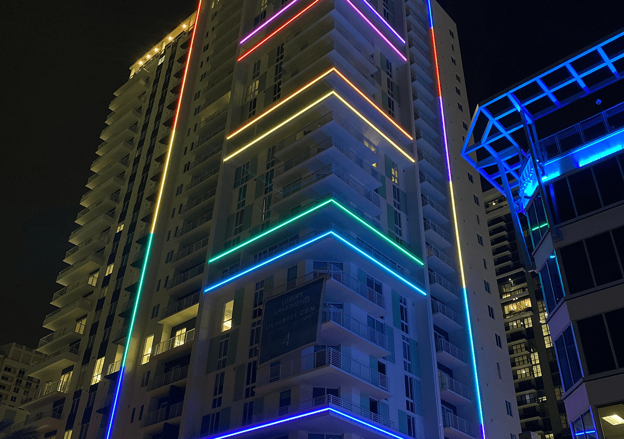 High-rise building adorned with colorful neon lights at night.