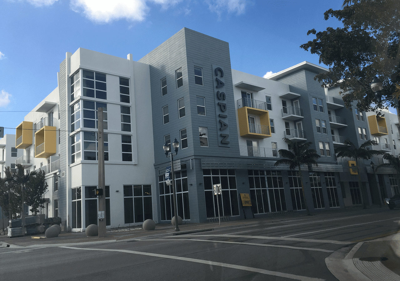 Modern multi-story building with large windows under a clear blue sky.