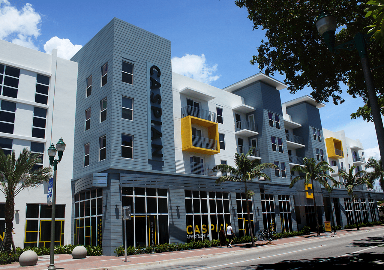 Modern apartment building with blue and white exterior and yellow balcony accents.