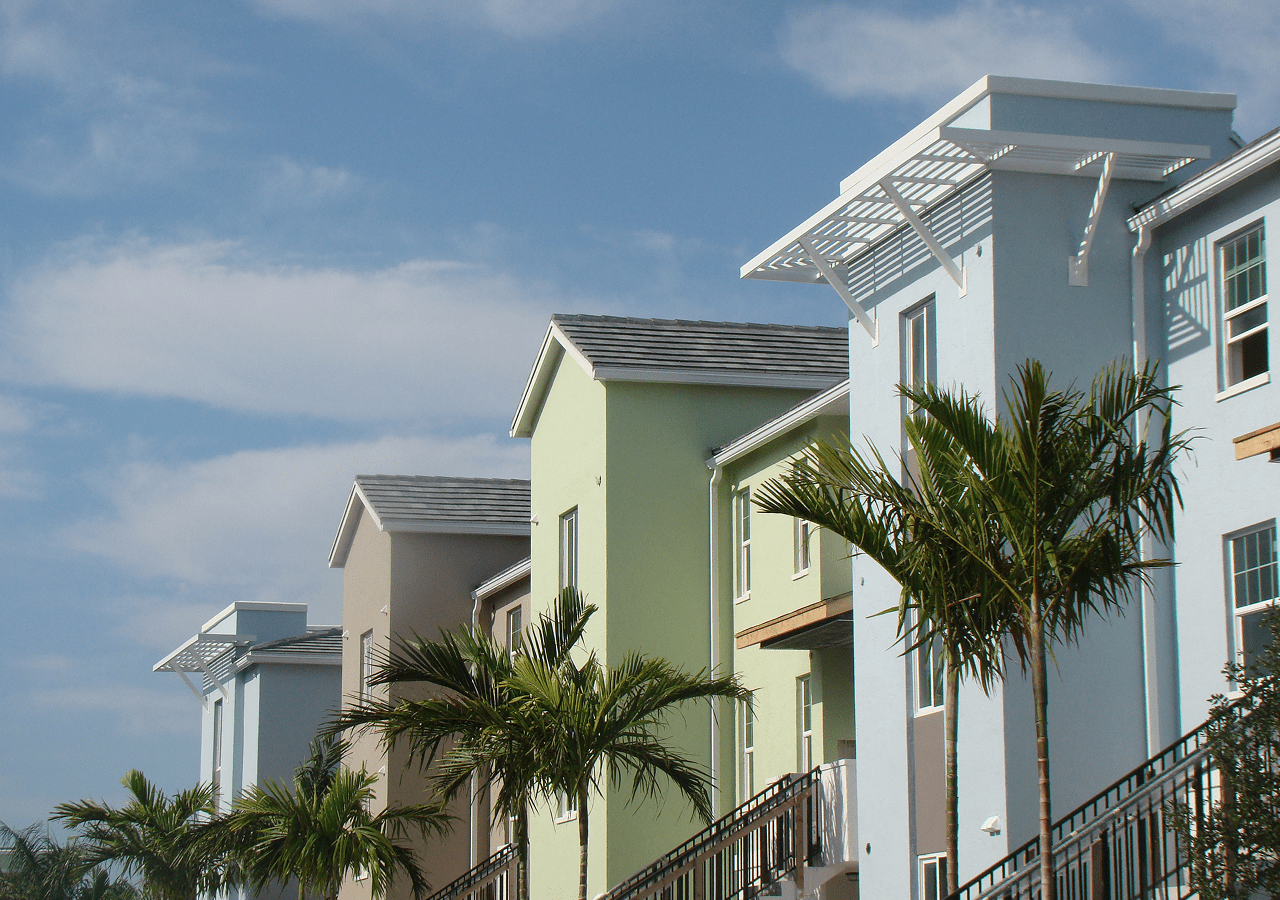 Colorful houses with palm trees under a clear blue sky.