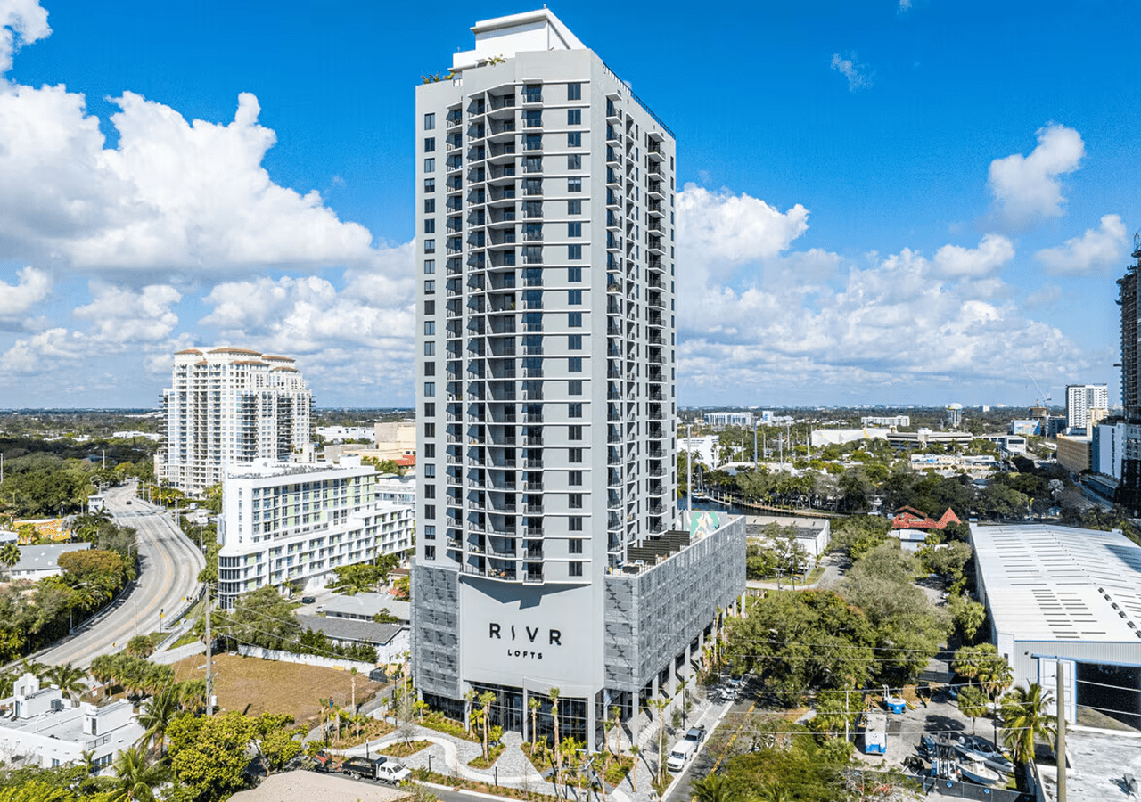 Tall modern residential building under a blue sky.