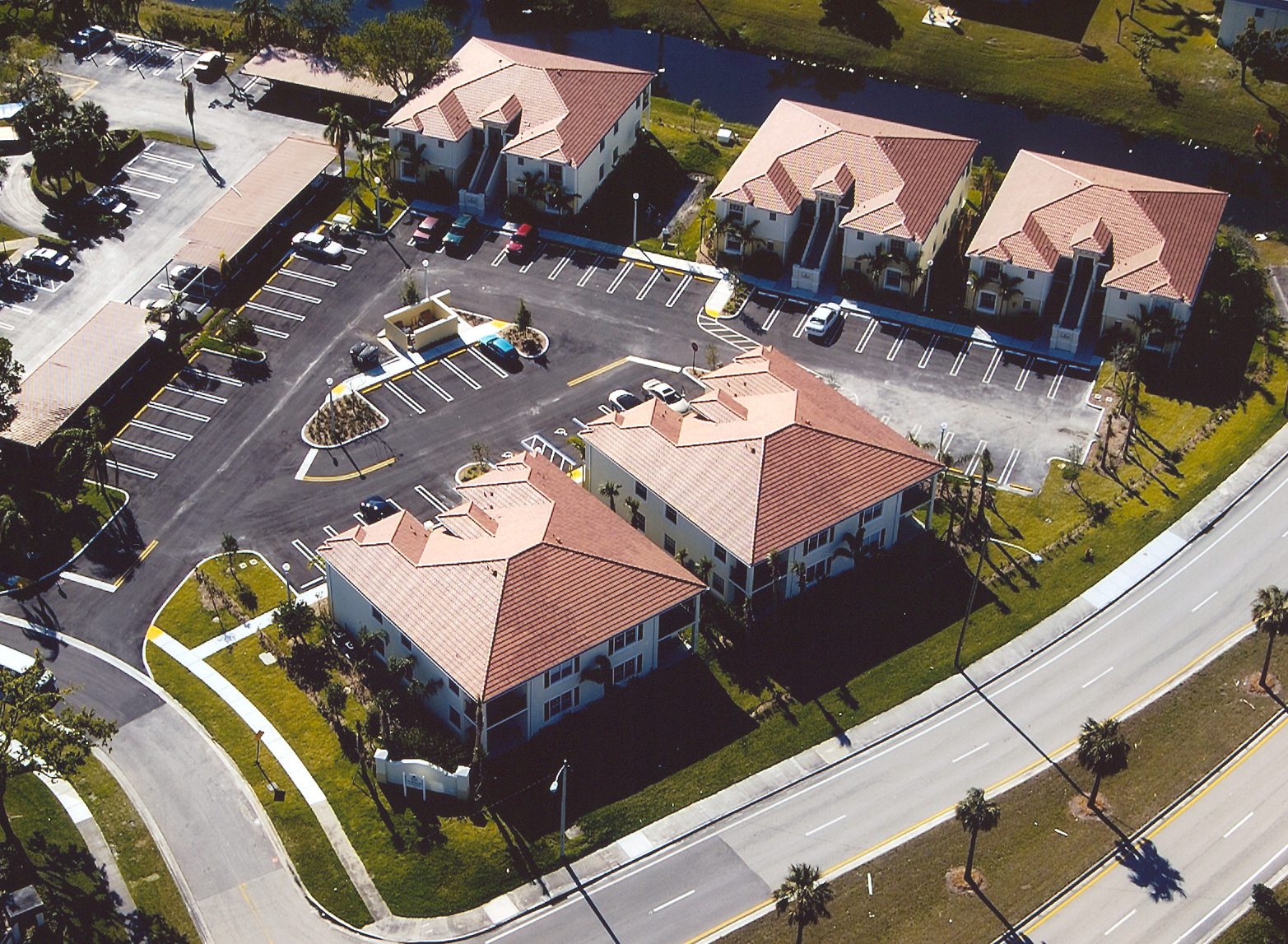 Aerial view of a commercial building complex with parking lots and surrounding roads.
